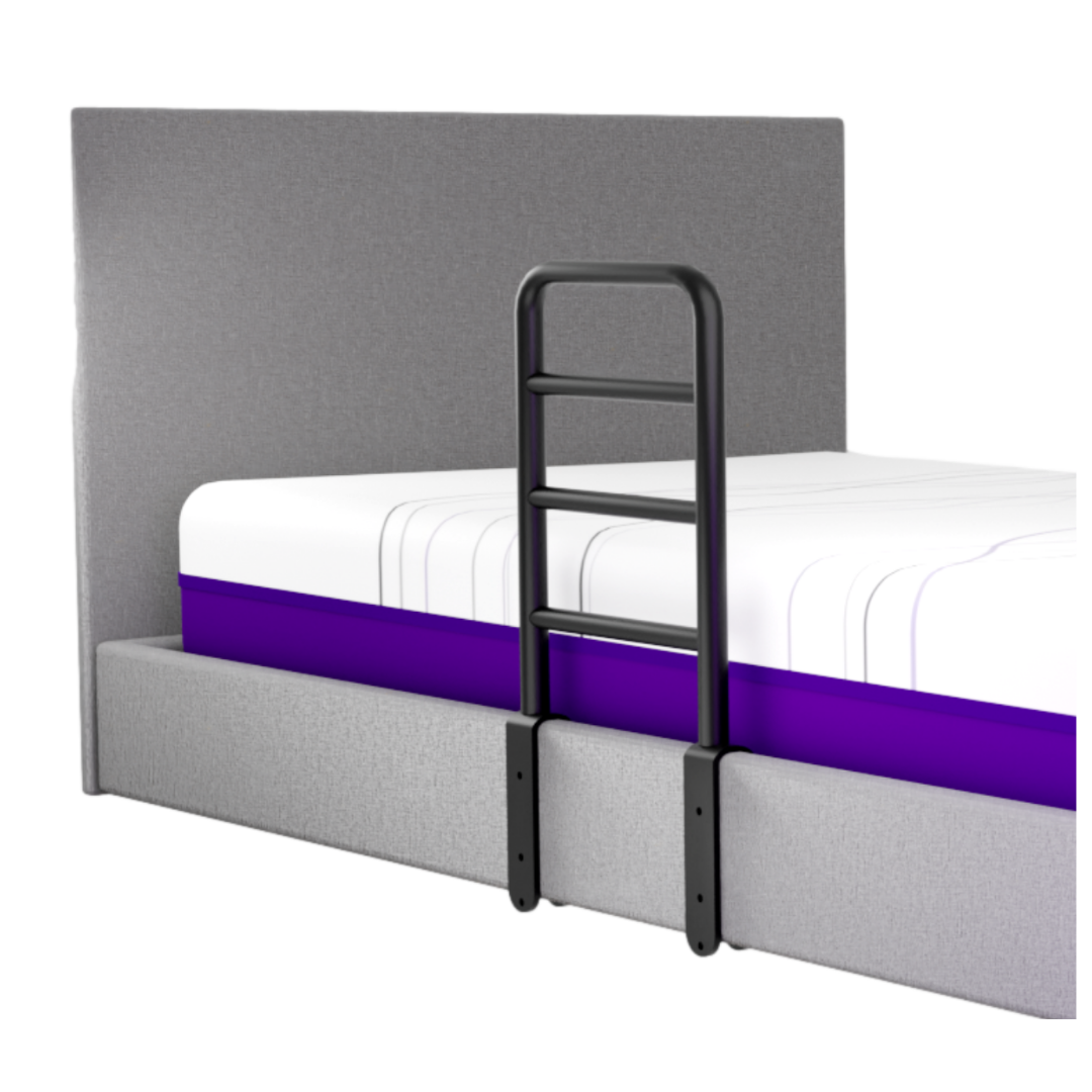 The iCare Medical Bed Safety Rails provide support and fall prevention, securely attached to a modern grey upholstered bed with a headboard and a mattress featuring a purple stripe.